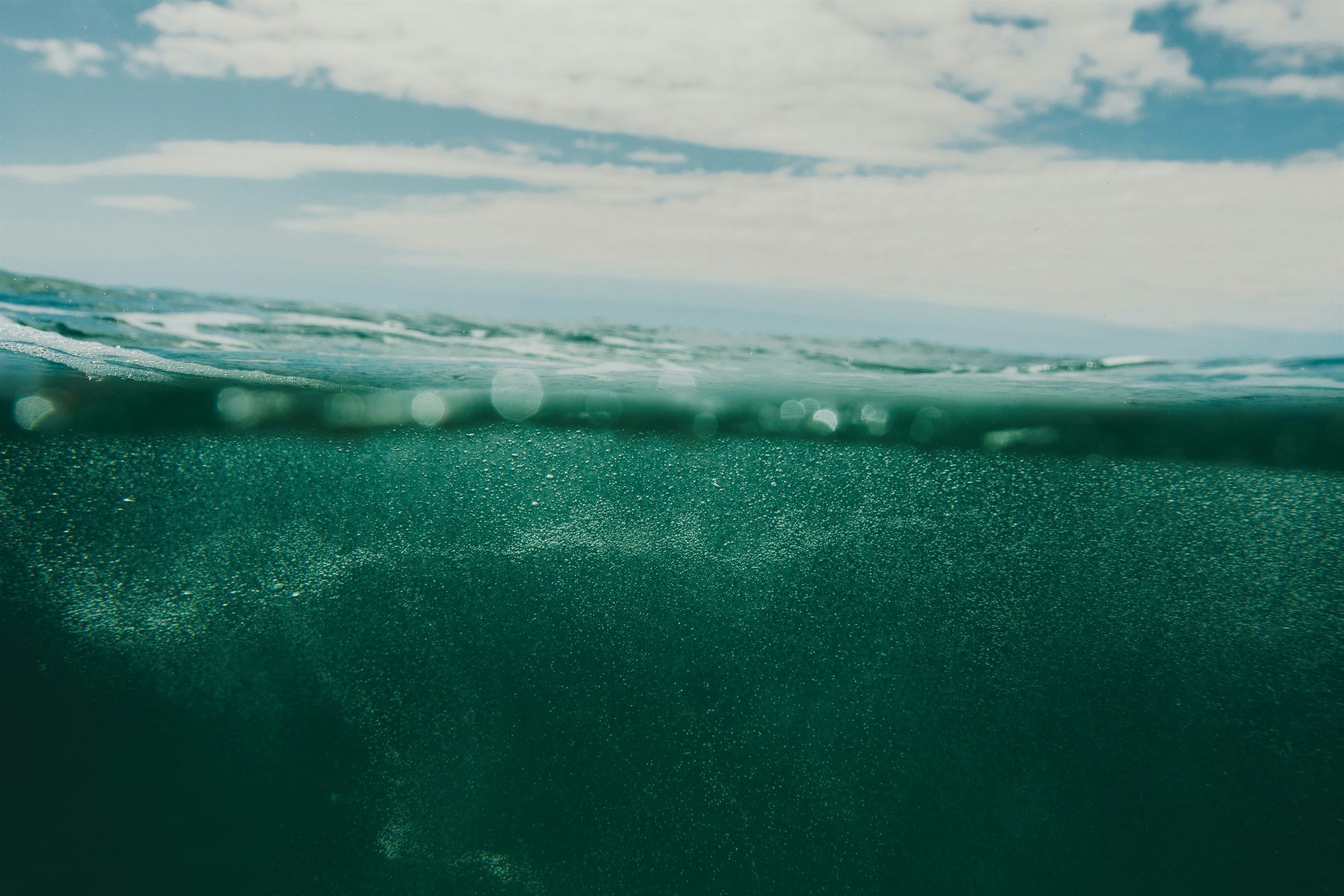 Blick von unter der Wasseroberfl&auml;che auf das Meer