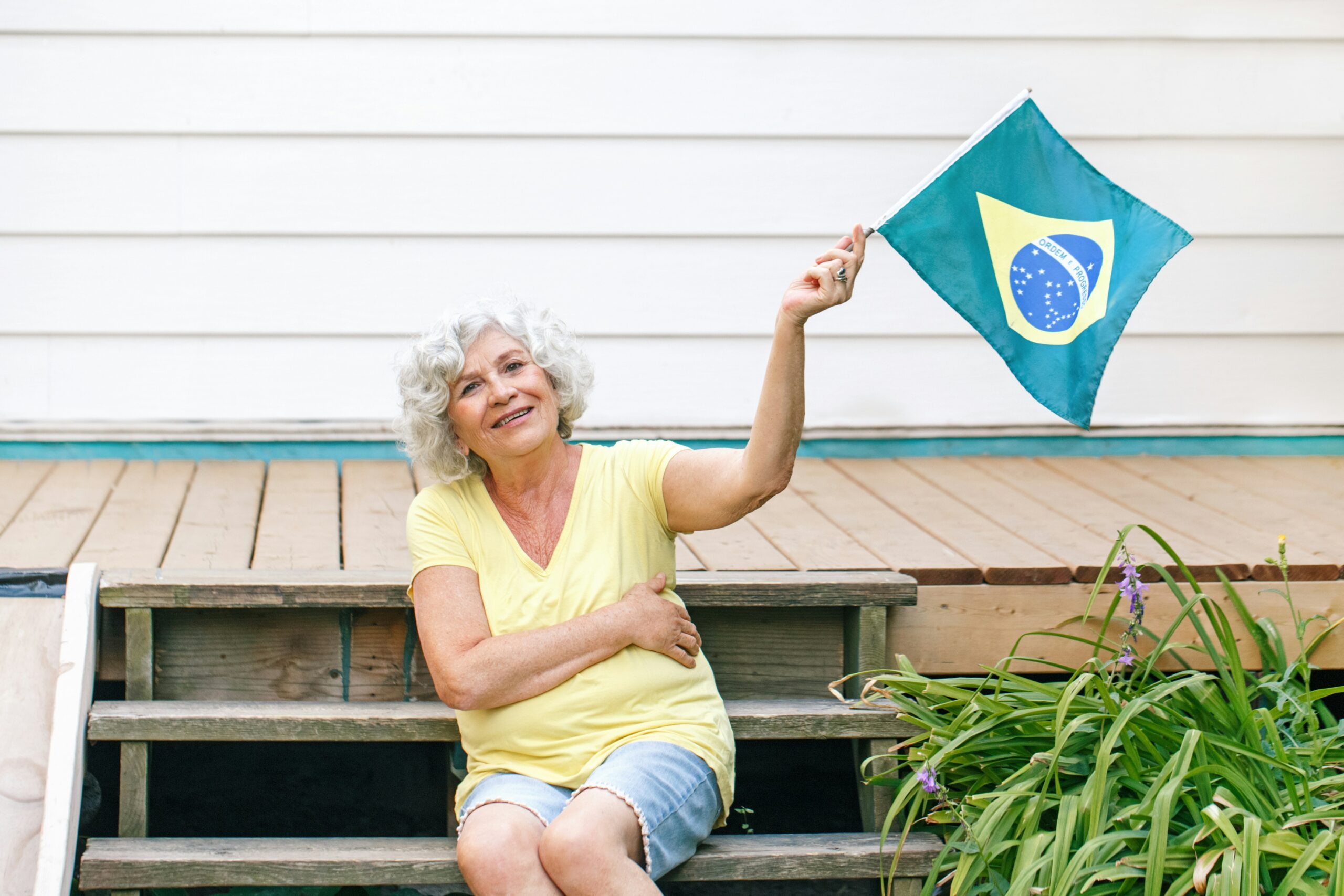 Einbürgerung Brasilien – Brasilianerin hält stolz die brasilianische Flagge