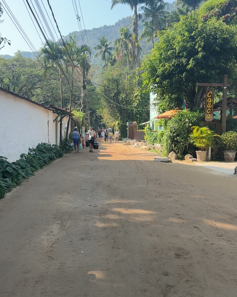 Sandstrasse ohne Autos in Abraão mit Palmen und Fussgängern