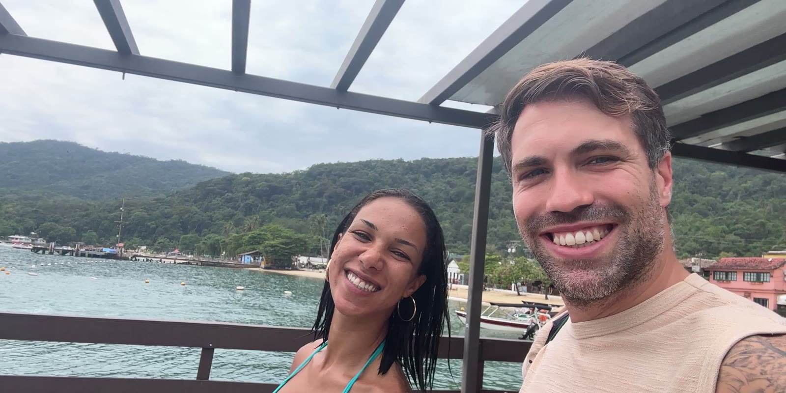 Selina und Nicola von RioMove lachen in die Kamera, am Steg von Abraão auf der Ilha Grande
