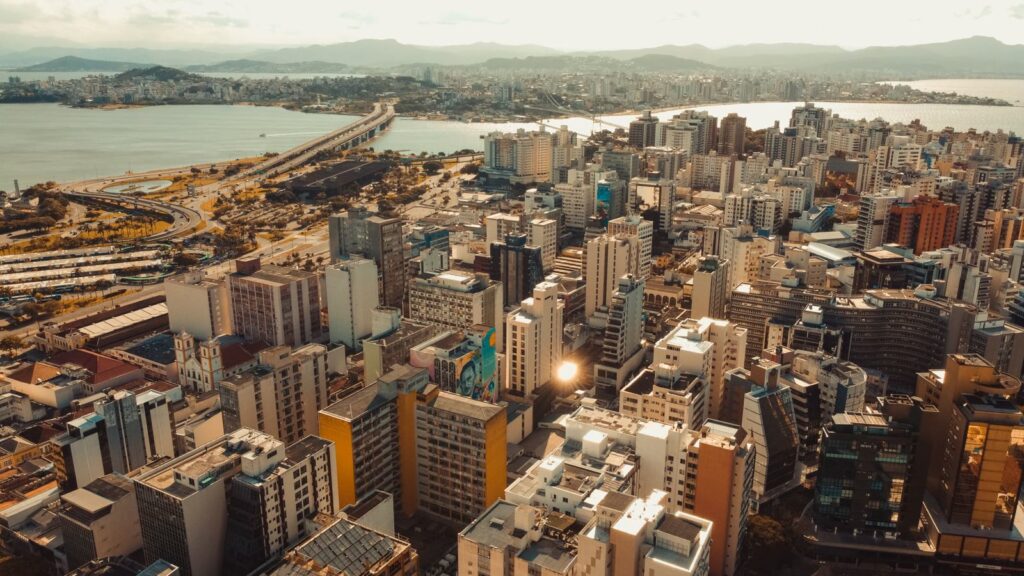 Wohnhochhäuser im Zentrum von Florianópolis aus der Luft, dahinter die Brücken zum Festland